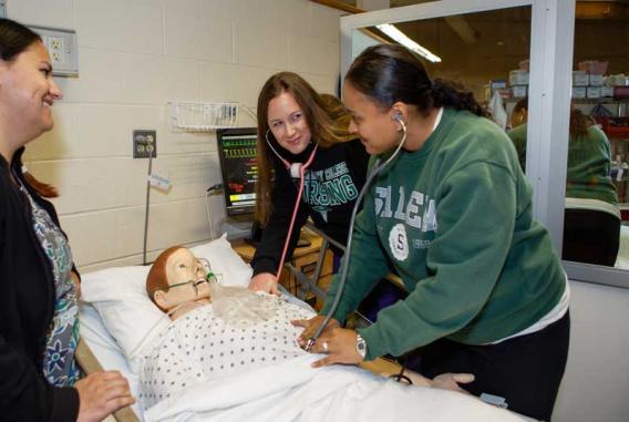 Nursing students practicing on dummy